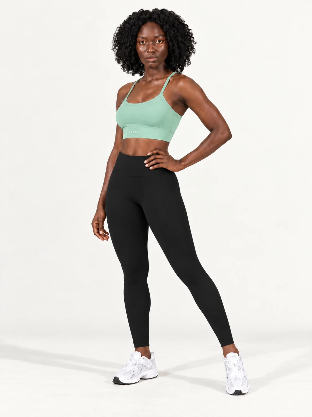 Imagem ilustrativa — Top Burpee BRAVA na cor Verde Menta, pose ¾ com mão na cintura.