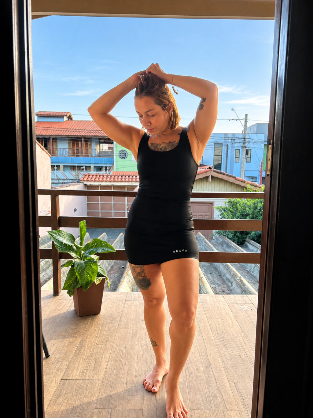 Mulher vestindo o macaquinho Âncora Brava na varanda.
